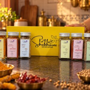 Shubhavni Stone Ground Spices Box set out in a home kitchen with whole haldi, chillies and dhaniya
